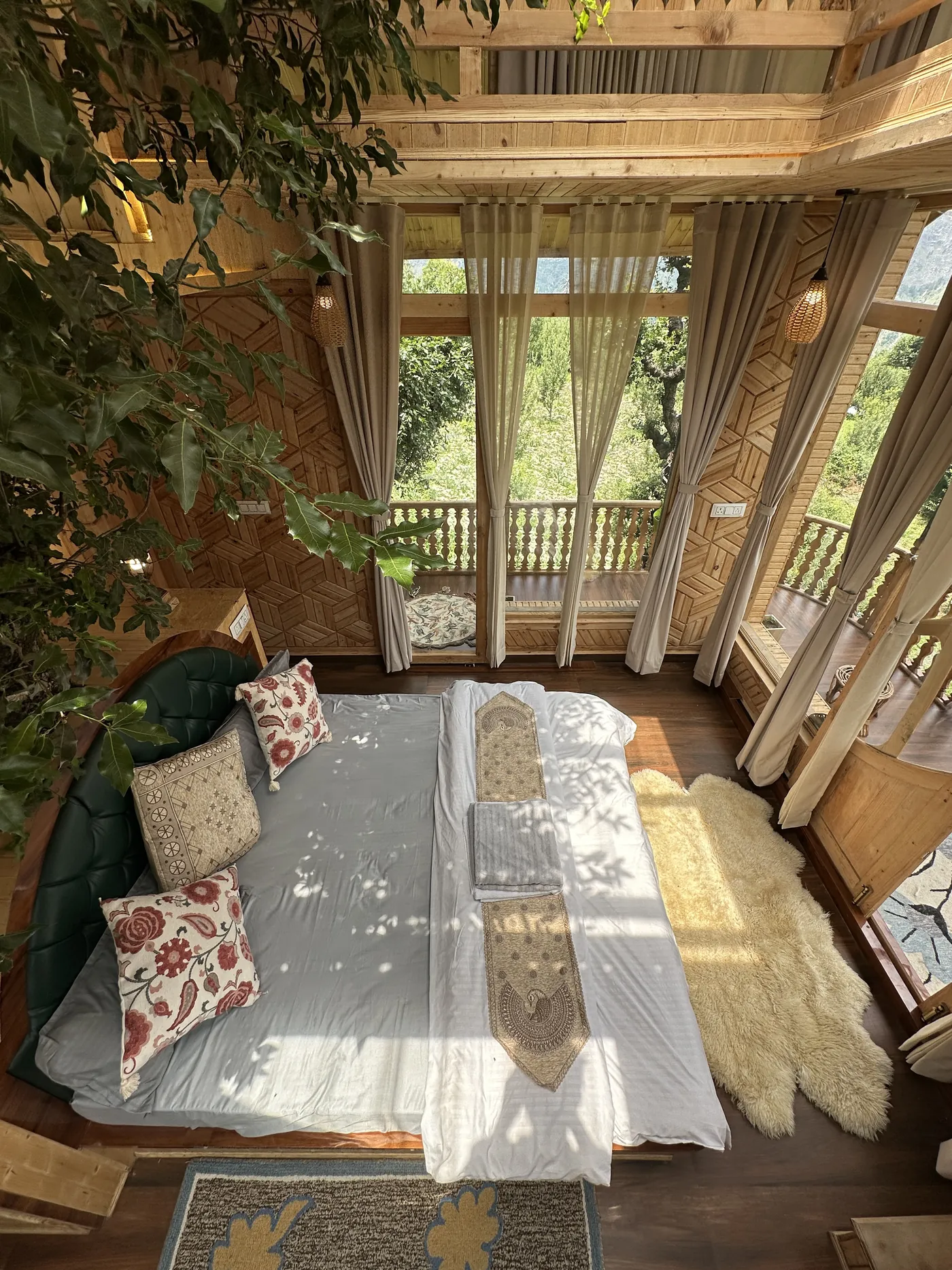 The Duplex Tree House king bed seen from above with the tree and balcony