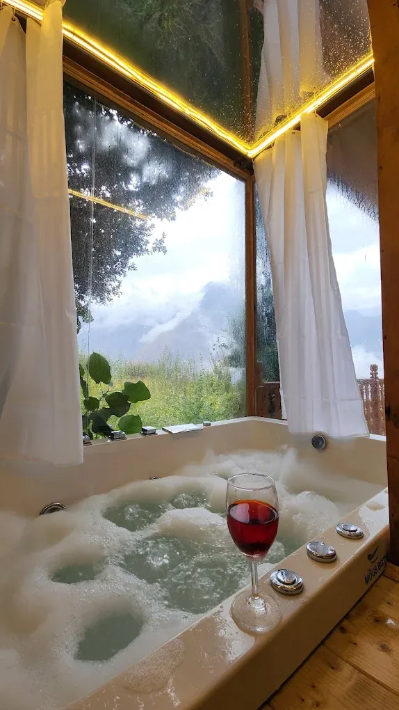 Private jacuzzi beside a glass wall with mountain views