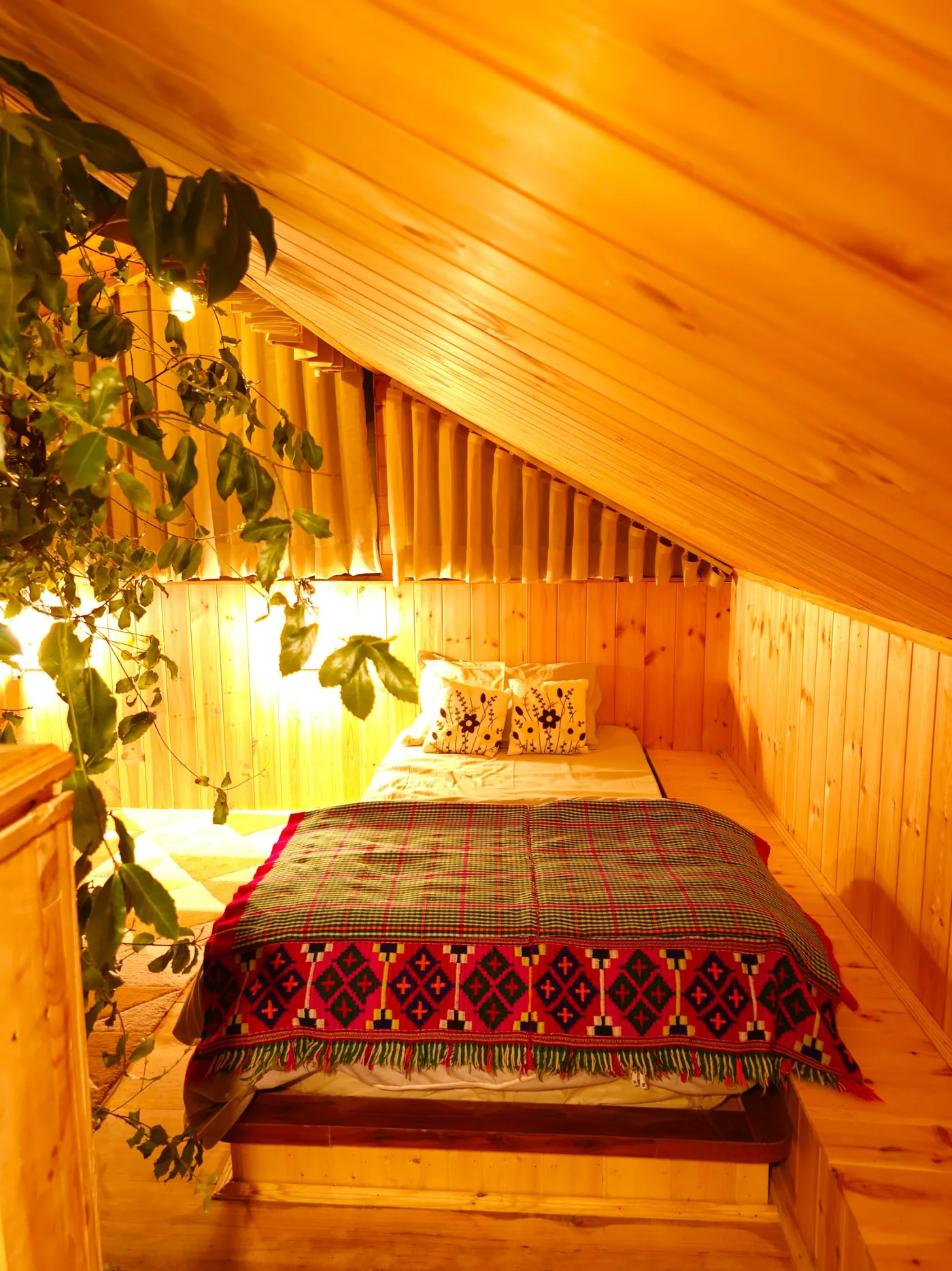 Loft bed with embroidered cushions and a hand-woven Himachali blanket